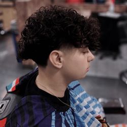 Kreative - Mid skin taper with natural wavy curls Haircut by Bryant #local barber