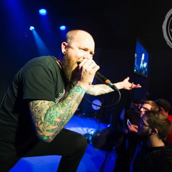 Cup O' Joy - man with a beard and tattoos singing into a microphone - Music Venues Near Me - Green Bay, Wisconsin Cup O' Joy - man with a beard and tattoos singing into a microphone - Music Venues Near Me - Green Bay, Wisconsin
