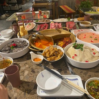 XiaoLongKan - a table full of asian food - Hot Pot Near Me - Queens, New York