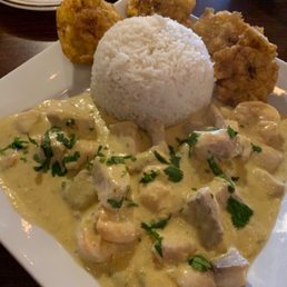 Shrimp and fish in coconut sauce with fried green plantains. Shrimp and fish in coconut sauce with fried green plantains.