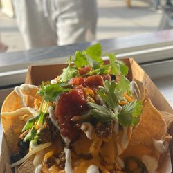 The Jetty - Loaded Nachos, seasoned angus ground beef, black beans, nacho + shredded cheese, salsa, sour cream, jalapeños, cilantro.