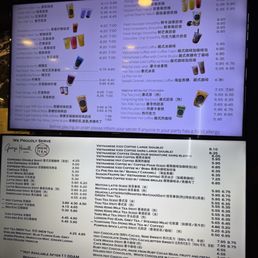 A digital menu board displays a variety of drinks including Vietnamese iced coffee, smoothies, teas, and hot chocolate. The menu lists prices for each item, with some drinks available in different sizes or variations. The menu also features specialty drinks like butterfly pea flower tea, lychee peach yakult, and matcha latte, along with descriptions and pricing. The bottom section shows a list of additional beverages and their prices, including espresso, milk teas, and hot chocolate, with notes about food allergies and service hours.