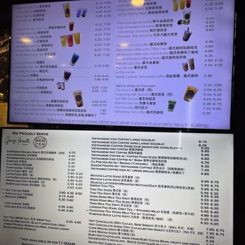 Cafe Darq - A digital menu board displays a variety of drinks including Vietnamese iced coffee, smoothies, teas, and hot chocolate. The menu lists prices for each item, with some drinks available in different sizes or variations. The menu also features specialty drinks like butterfly pea flower tea, lychee peach yakult, and matcha latte, along with descriptions and pricing. The bottom section shows a list of additional beverages and their prices, including espresso, milk teas, and hot chocolate, with notes about food allergies and service hours. - Asian Fusion Near Me - Boston, Massachusetts