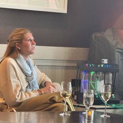 Alpine Oxygen - Guest seated at a table while using an oxygen breathing tube from an Alpine Oxygen bar system.