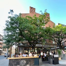 people sitting at tables in front of a building