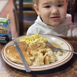 Canyon Alpine Restaurant - Kids Hotcake with scrambled eggs and apple juice and a happy girl with a mouth full of hotcakes