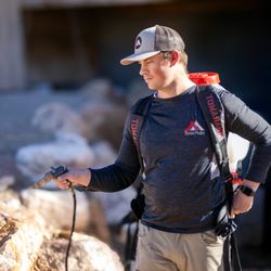 Three Peaks Pest Control - Three Peaks Pest Control Technician Spraying rocks for spiders and scorpions.