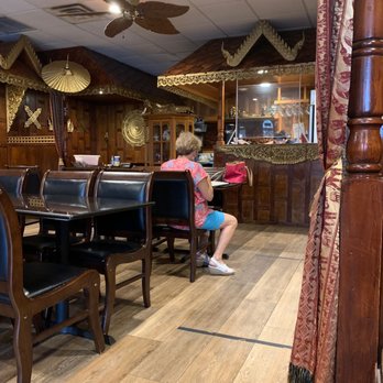 Thailand Restaurant - a woman sitting at a table - Thai Near Me - Sarasota, Florida Thailand Restaurant - a woman sitting at a table - Thai Near Me - Sarasota, Florida