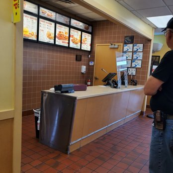 Bojangles - a man standing in front of a counter - Burgers Near Me - Marshville, North Carolina