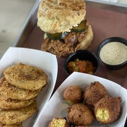 Fried chicken sandwich, fried green tomatoes and hush puppies Fried chicken sandwich, fried green tomatoes and hush puppies