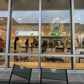 sweetgreen - Healthy Salads, Wraps, and Bowls - a view of the outside of a restaurant - Inside a sweetgreen restaurant, customers are waiting in line and ordering at the counter, visible through large glass windows. - Salad Near Me - Cranston, Rhode Island