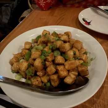 Thip Khao - A dish of stir-fried tofu cubes garnished with chopped green onions, served on a white plate at a restaurant. - Laotian Near Me - Washington, DC, District of Columbia