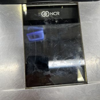 Meijer - Self check scanner - A NCR self-check scanner features a black, scratched, and smudged glass screen, set into a stainless steel surface. The device is used for checkout or payment processing in retail or grocery stores. The screen displays the NCR logo at the top, and reflections of nearby objects are visible on the screen surface. - Grocery Near Me - St. Charles, Illinois