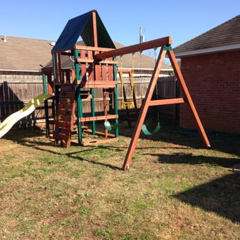Berry Construction - a wooden swing set in a backyard - General Contractors Near Me