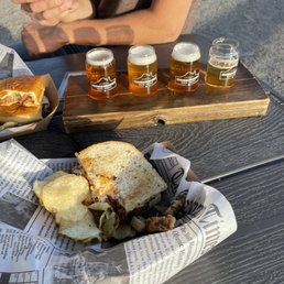 a picnic table with a sandwich and beer