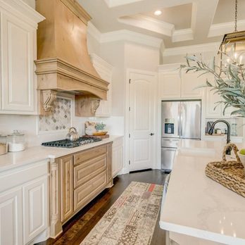 Couto Homes - a large kitchen with white cabinets and wood floors - General Contractors Near Me - Granbury, Texas
