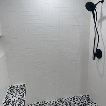 Rivas Custom Tile - a shower with black and white tile - General Contractors Near Me