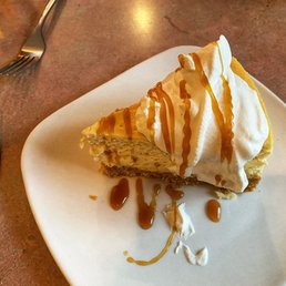 Dulce de Leche Cheesecake topped with whipped cream and caramel.