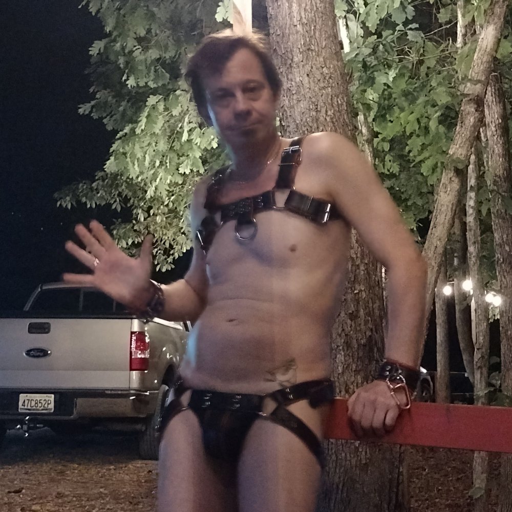 In Mr.S leather jock and harness at a forest party.