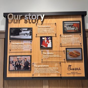 Chick-fil-A - A wooden-framed display board titled 'Our story' features photos and text detailing Chick-fil-A's history and growth. - Fast Food Near Me - Paramus, New Jersey