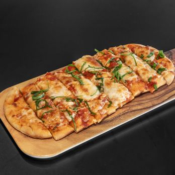 Tati - a flatbread pizza on a cutting board - Coffee & Tea Near Me - Madison, Wisconsin Tati - a flatbread pizza on a cutting board - Coffee & Tea Near Me - Madison, Wisconsin
