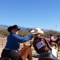 Cielo Tierra Ranch - 2 students of head to tail riding school helping one another before entering the show ring .