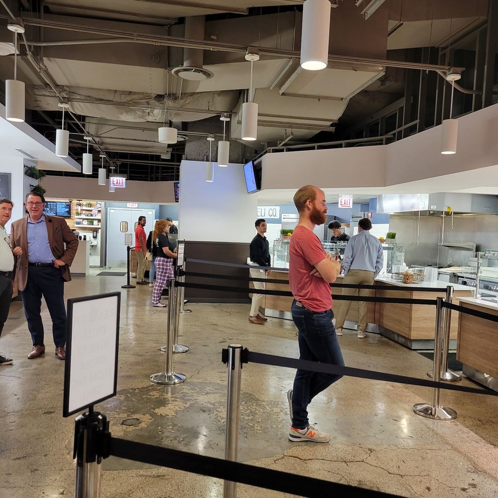 Rustle + Roux - a man standing in a food court - Cafeteria Near Me - Chicago, Illinois Rustle + Roux - a man standing in a food court - Cafeteria Near Me - Chicago, Illinois