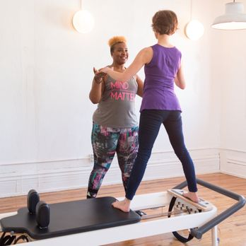 Center Pilates - Shauntel Douglas guiding a client in her group Reformer classes. - Pilates Near Me - Buffalo, New York Center Pilates - Shauntel Douglas guiding a client in her group Reformer classes. - Pilates Near Me - Buffalo, New York