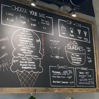 Batch Ice Cream - Menu 2025 - The chalkboard menu features sections for choosing ice cream sizes, toppings, sundaes, shakes, and drinks. It includes options for large, small, kiddie, and whole pint sizes, with prices. Toppings such as M+M's, Oreos, chocolate chips, and strawberries are listed, along with free whipped cream. Sundaes come in large and small sizes with various toppings. Shake options include milkshakes, root beer floats, and non-dairy smoothies, while drinks include water, root beer, hot coffee, and frozen lemonade. The menu is written in white and red chalk on a black background. - Ice Cream & Frozen Yogurt Near Me - Longmeadow, Massachusetts
