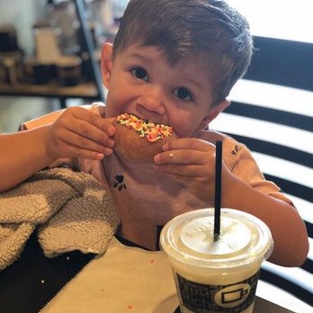 Coffee Beanery - a young boy eating a donut - Coffee & Tea Near Me - Monaca, Pennsylvania