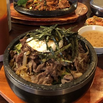 K Restaurant - Foreground: Dolsot bibimbap, comes with miso soup. Background: spicy pork that comes with white rice and kimchi. - Korean Near Me - Peabody, Massachusetts