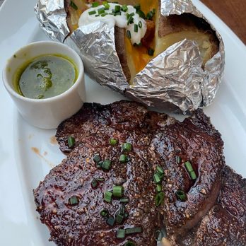 Maison Pucha Bistro - 10oz ribeye served with a baked potato, chimichurri sauce, & a complimentary 3 oz. glass of wine ($25) - French Near Me - Houston, Texas Maison Pucha Bistro - 10oz ribeye served with a baked potato, chimichurri sauce, & a complimentary 3 oz. glass of wine ($25) - French Near Me - Houston, Texas
