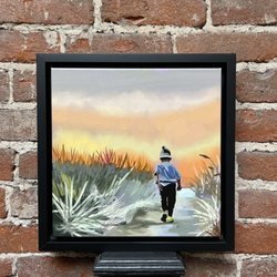 Lumaprints - Painting in black frame of young boy in sand dunes, against brick wall