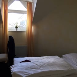 Hotel Astoria - Winziges DG-Zimmer. Vorhänge hauchdünn und decken nicht mal das spitzzulaufende Fenster komplett ab. Gegenüber: Leuchtreklame. Gute Nacht!