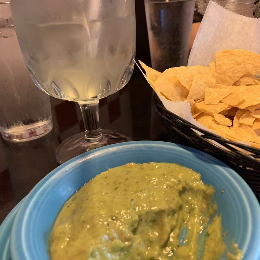 Lime margarita on the rocks, guacamole dip and chips Lime margarita on the rocks, guacamole dip and chips