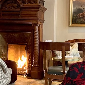 The Stewart - a woman sitting in a chair in front of a fireplace - Whiskey Bars Near Me - Easton, Maryland The Stewart - a woman sitting in a chair in front of a fireplace - Whiskey Bars Near Me - Easton, Maryland