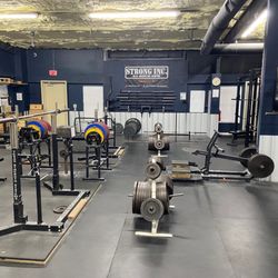 Strong Inc 24hr Gym - The powerlifting area at Strong Inc. Bench presses, squat racks, a pair of deadlifting stations, power racks, belt squat machine.