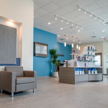 Hand & Stone Massage and Facial Spa - Spacious reception area with light beige tile flooring and white grid ceiling with track lighting... - Massage Near Me - Miami, Florida Hand & Stone Massage and Facial Spa - Spacious reception area with light beige tile flooring and white grid ceiling with track lighting... - Massage Near Me - Miami, Florida