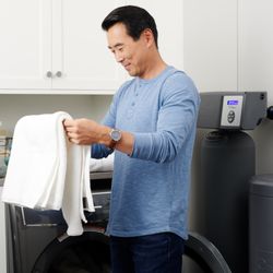 Culligan - Man folding soft laundry after using Culligan's soft water