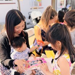 A sweet moment from our Mother's Day celebration! This child is proudly presenting her mom with a special handmade gift.