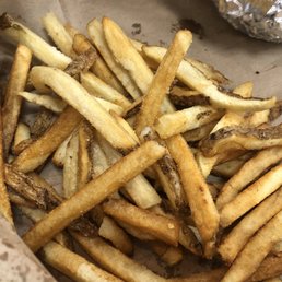 a pile of french fries in a paper bag