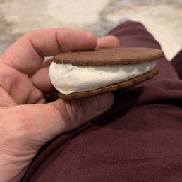 a hand holding a cookie sandwich a hand holding a cookie sandwich