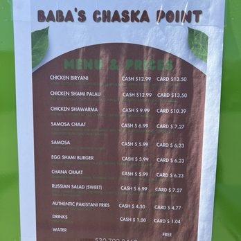 Baba’s Chaska Point - Menu Sept, 2024 - The menu at Baba's Chaska Point food truck in Davis, CA, lists Pakistani cuisine options including chicken biryani, shami palau, chicken shawarma, samosa chaat, and egg shami burger. Prices are provided for cash and card payments, with additional options for Russian salad, Pakistani fries, drinks, and water. The menu is printed on a sheet attached to a green surface, with decorative leaves and a contact phone number at the bottom. - Food Trucks Near Me - Davis, California