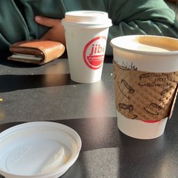 a man sitting at a table with two cups of coffee a man sitting at a table with two cups of coffee