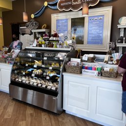 a woman standing in front of a bakery counter