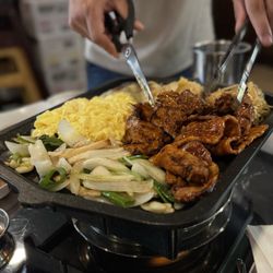 Seoul Belly - thinly sliced spicy pork belly heated over a burner + other sides on the metal tray