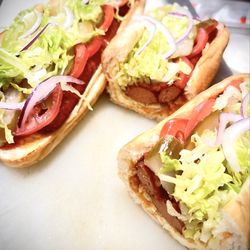 Uncle Af's - LA G.O.A.T ( beef sausage, Firecracker aioli , Swiss, ketchup, Persian pickles, tomatoes, raw onions, chips, shredded lettuce, balsamic vine
