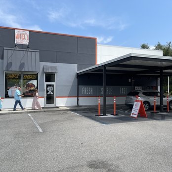 MotLee's - The side entrance and drive-through at Mottlee's, which has some outdoor tables at the left. - Fast Food Near Me - Macclenny, Florida