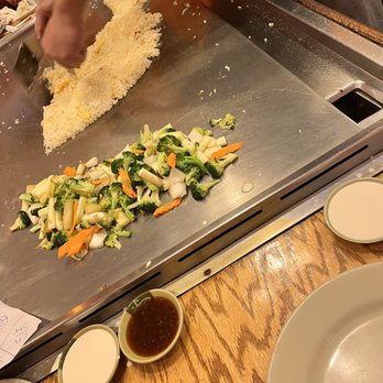 Sake Japanese House - a person preparing food on a grill - Japanese Near Me - Mebane, North Carolina Sake Japanese House - a person preparing food on a grill - Japanese Near Me - Mebane, North Carolina