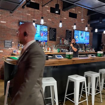 Belmont Hall - a man standing at the bar - Sports Bars Near Me - Elmont, New York